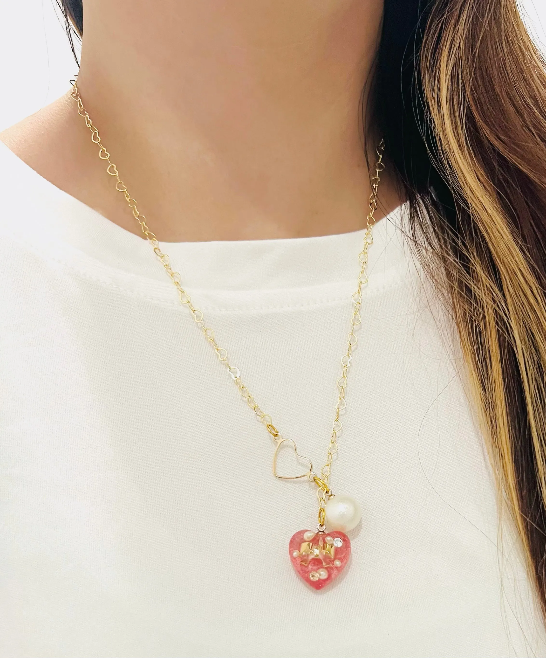 Heart-shaped gold necklace with hanging red heart