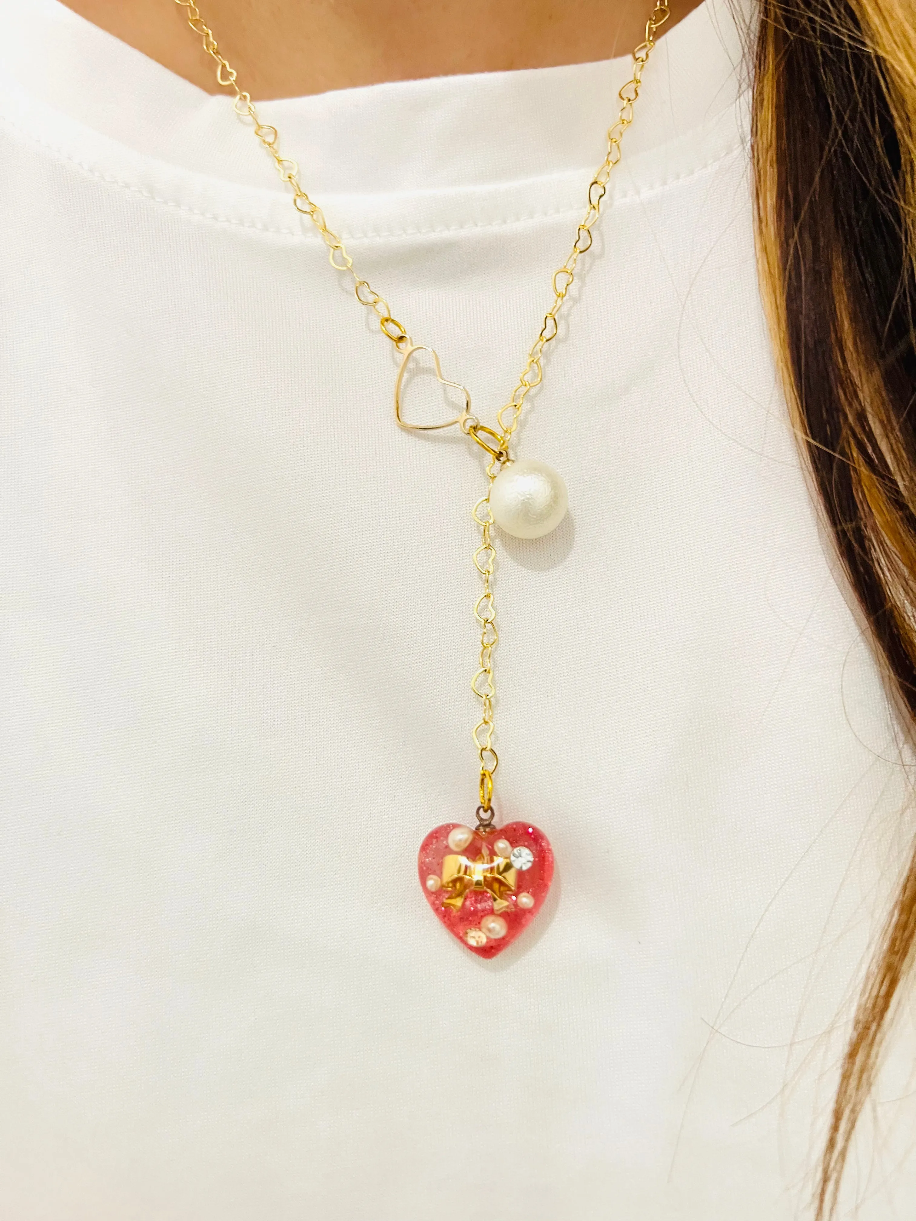 Heart-shaped gold necklace with hanging red heart