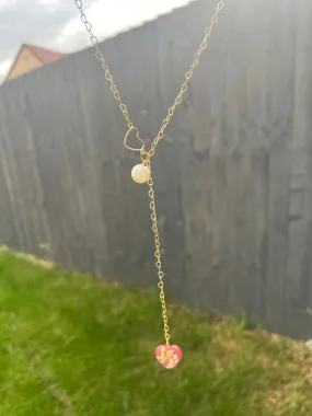 Heart-shaped gold necklace with hanging red heart