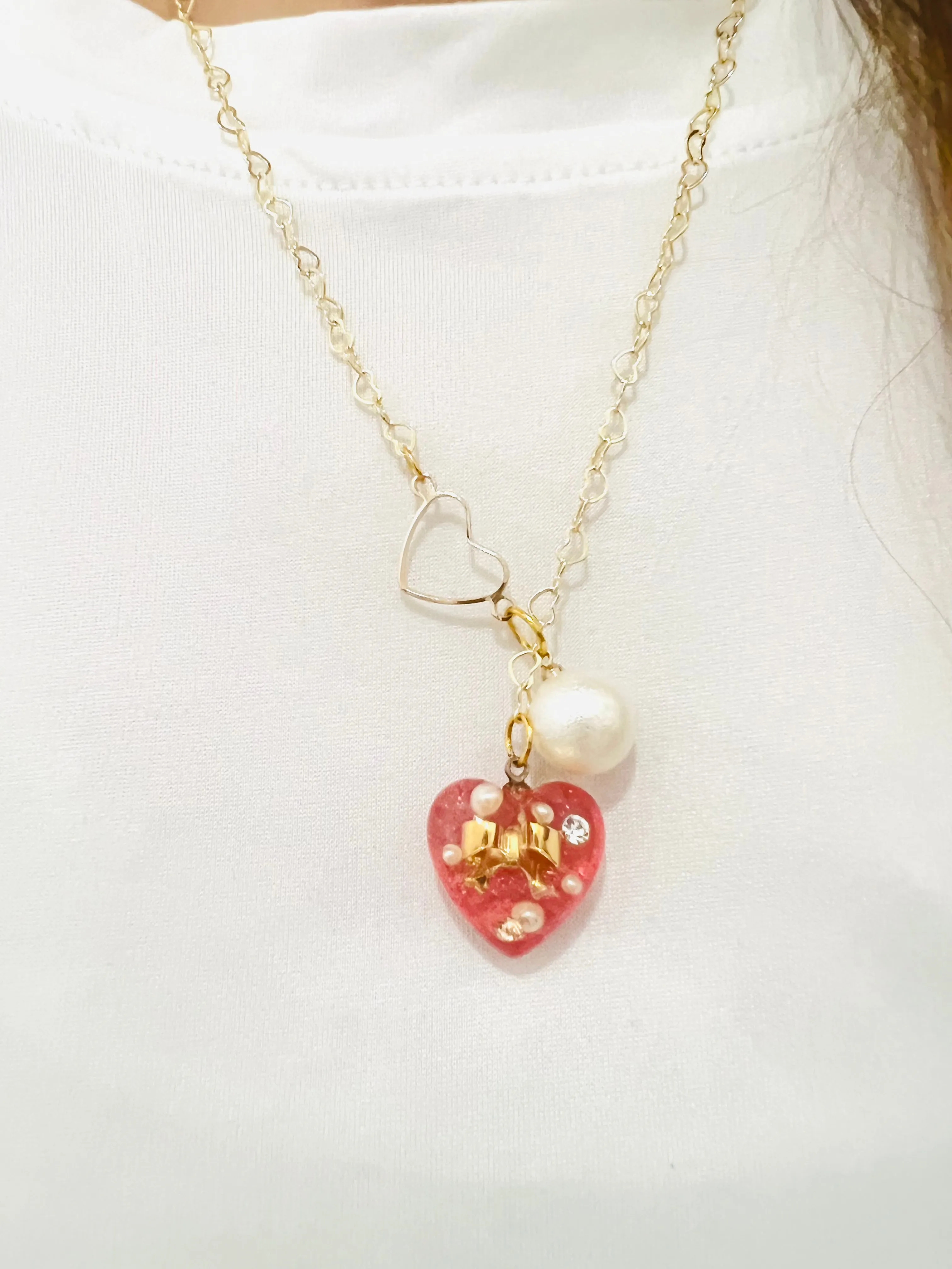 Heart-shaped gold necklace with hanging red heart